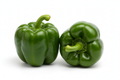 two green bell peppers on white background